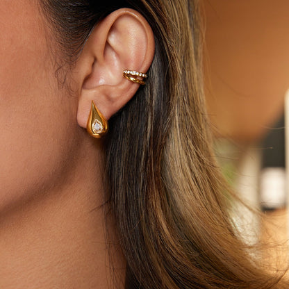 18K gold earrings inlaid with cubic zirconia in a teardrop design.